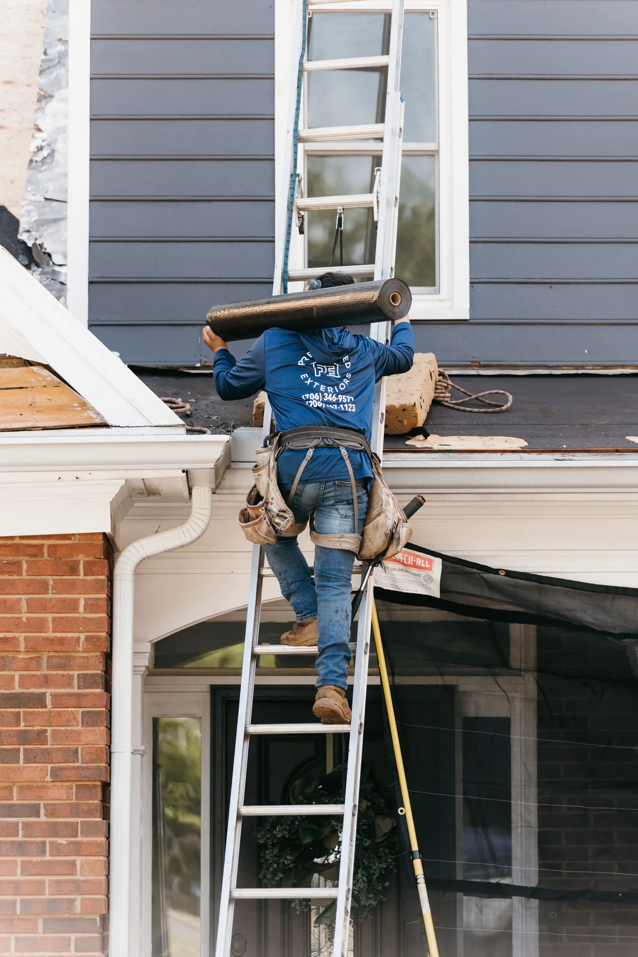 Wind-damaged asphalt shingles being documented and removed during an Atlanta roof insurance claim inspection