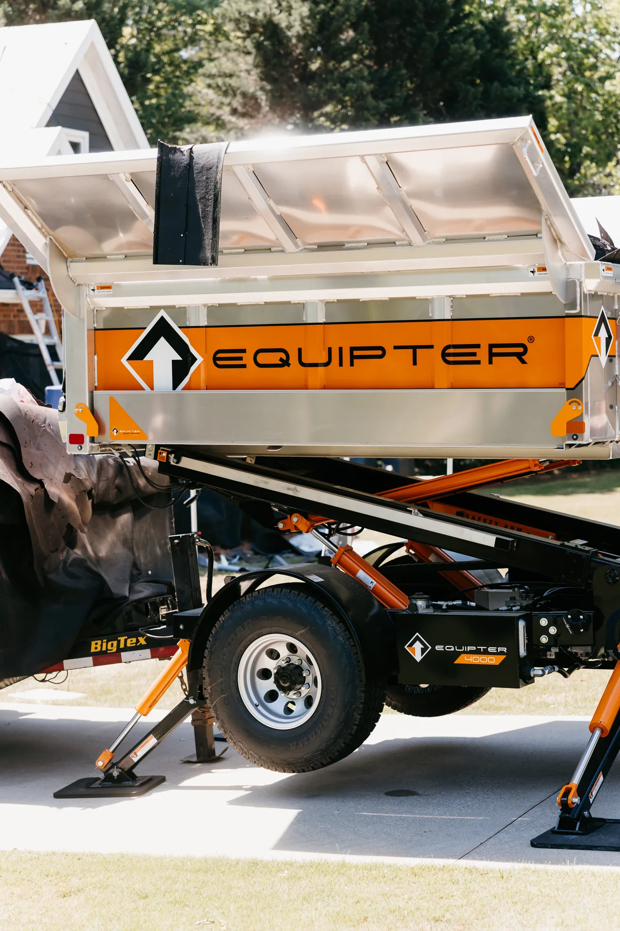 Preferred Roofing crew using an Equipter dump trailer on a job site